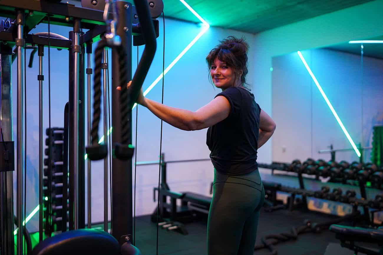 Een vrouw bij een krachttoestel in de gym van Jouw Krachtstation.